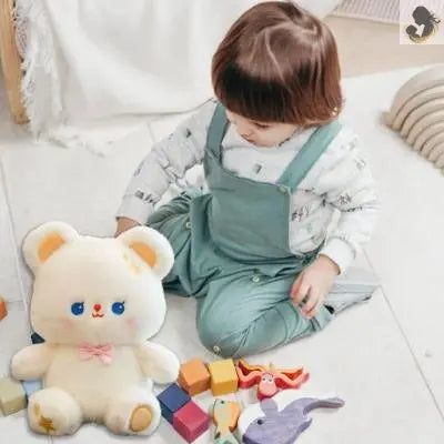 Ours doudou blanc qui joue avec une petite fille au lit
