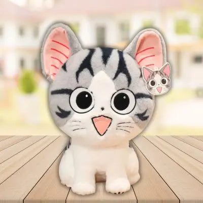 Kawaii peluche chat blanc soyeux assis sur une table sourire flatteur peluche chat