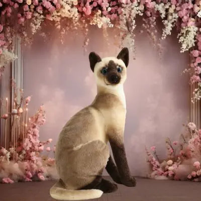 Peluche chat réaliste-peluche chat photogénique dans un cadre parmi les fleurs