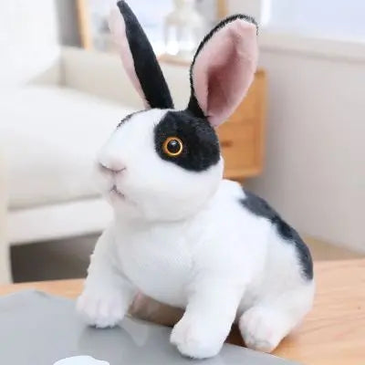 Peluche lapin réaliste assis le blanc au dos et yeux noirs 