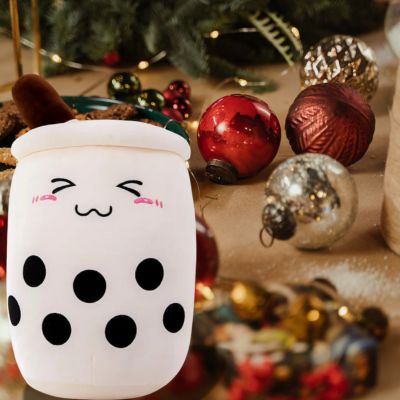 Peluche bubble tea lait à Noël sur la table avec de beaux ornements