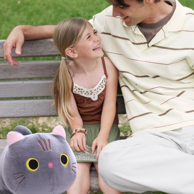 Peluche chat-adorable peluche kawaii aux yeux brillants au jardin avec fille et papa