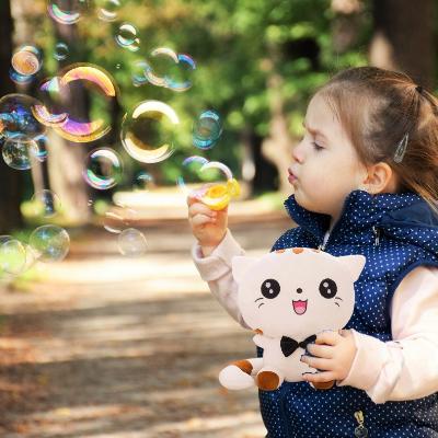 Peluche kawaii-peluche chat avec fillette souriante qui joue au jardin