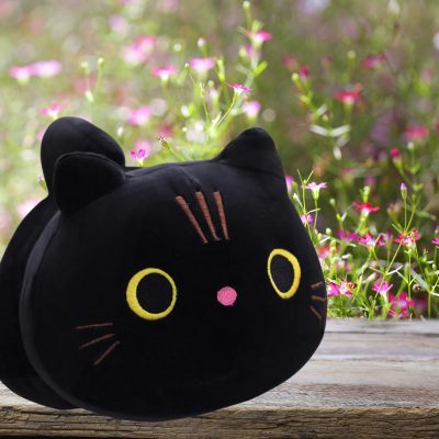 Peluche chat-peluche kawaii noir avec nez rose sur la table du jardin