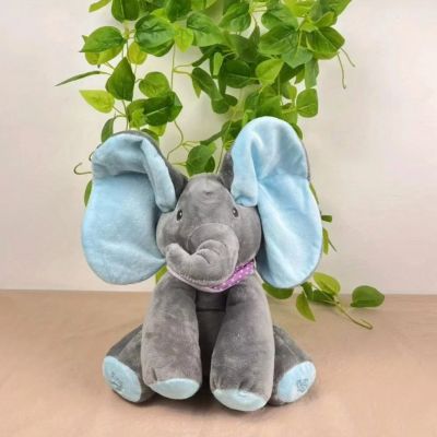 Peluche elephant gris avec magnifiques oreilles bleues dansantes assis au salon