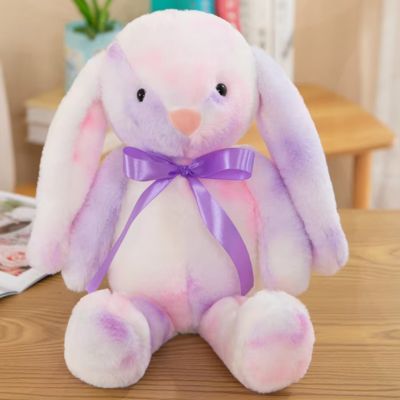 Peluche lapin mauve adorable au ruban satiné de couleur violet assis au pupitre