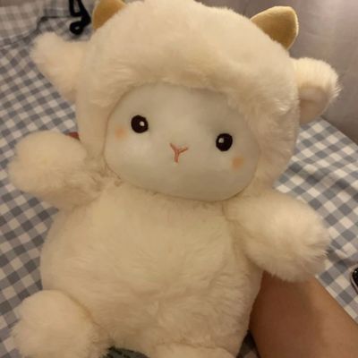 Peluche mouton beige aux petits yeux assis au salon