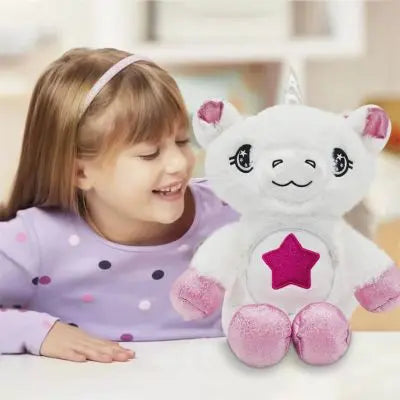 Peluche licorne blanche aux joyeux yeux étoilés assise avec fille joyeuse