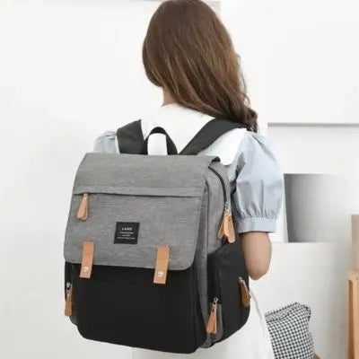 Sac a langer-gris-noir-avec-fille-de-dos heureuse qui porte son sac a dos a langer