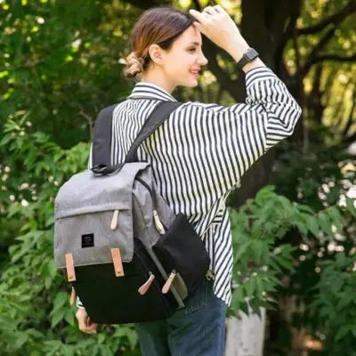 sac a langer gris-noir porté par une jeune maman en-camping