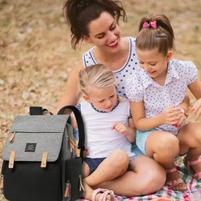 Sac a langer-noir-et-gris avec-famille-de deux-enfants-en-camping