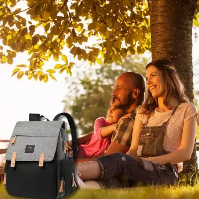 Sac a langer-noir-et-gris-avec-parents-en-camping